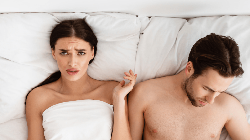 Stel man en vrouw in bed , man kijkt naar beneden , impotentie kan meerdere oorzaken hebben gelukkig is Cobra 120 mg de rode erectiepil met 120mg sildenafil tegen impotentie